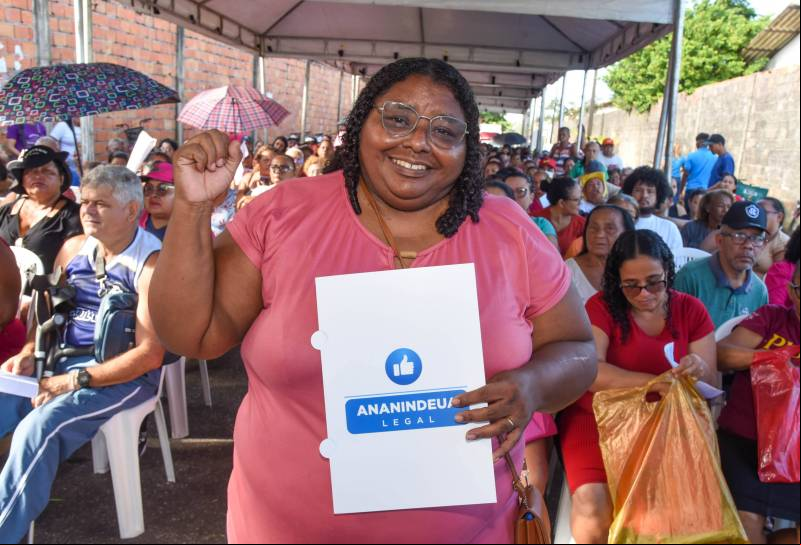 Moradora feliz com seu documento de propriedade.